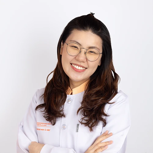 Portrait of a Thai female dentist wearing a white coat and smiling